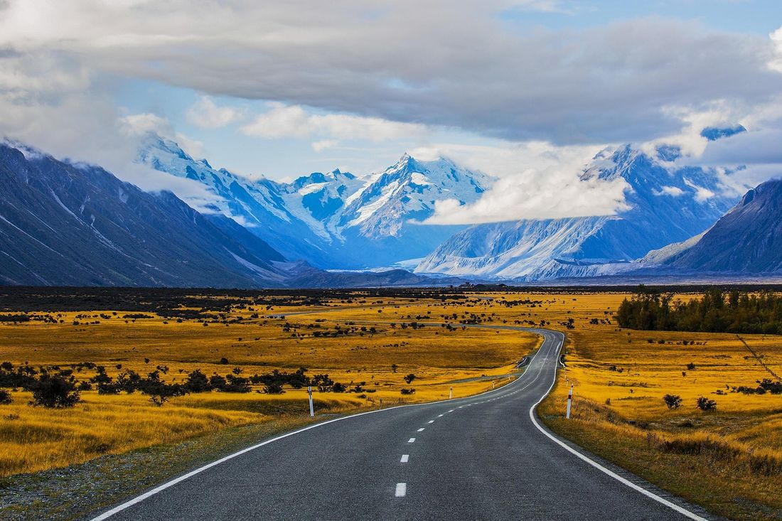 Open road winding toward distant mountains under a wide sky